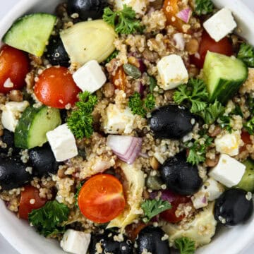 Mediterranean lentil quinoa salad in a white bowl.