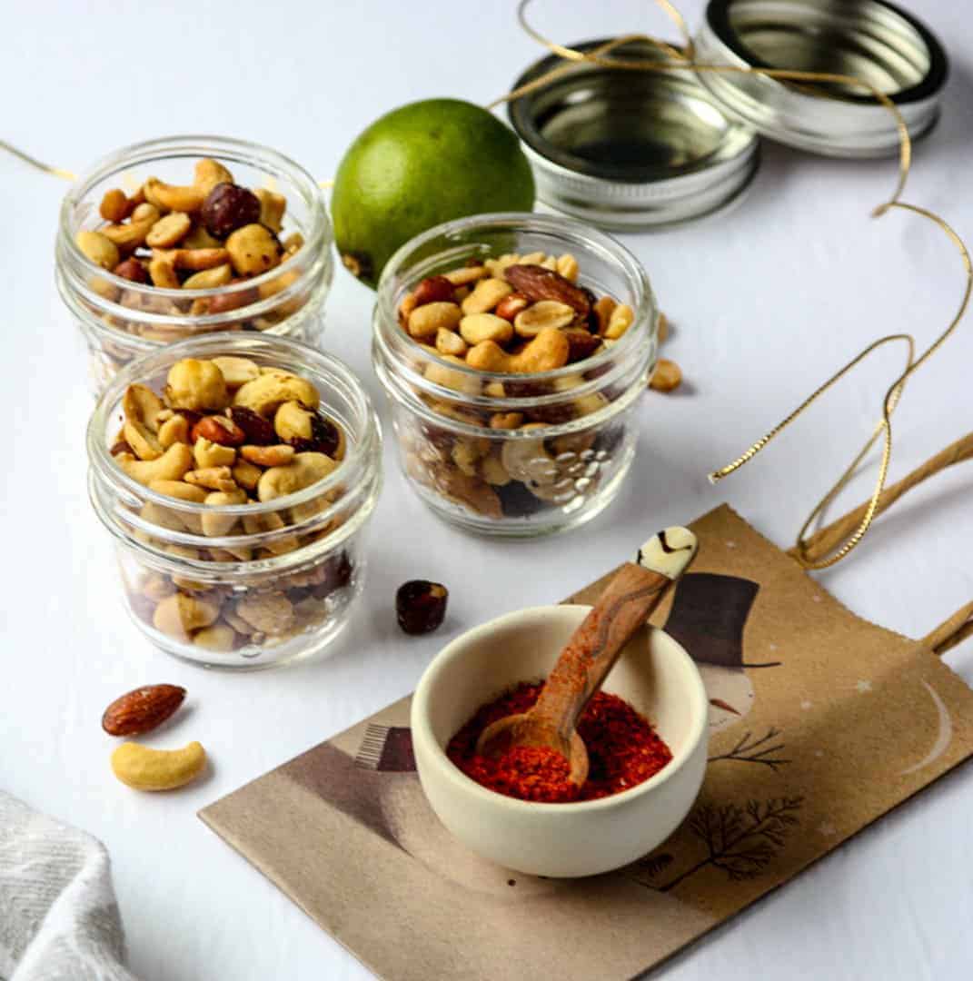Three glass jars of mixed nuts on a table