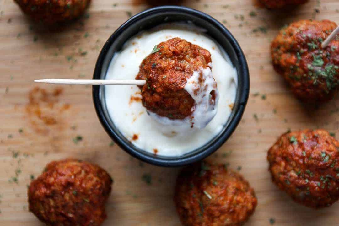 A meatball being dipped in sauce