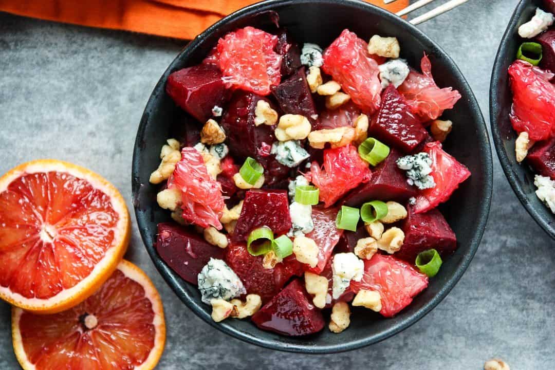 Salad with nuts and blue cheese crumbles in black bowls