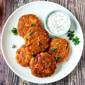 Several salmon patties on a white plate.