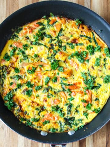Salmon fritatta in a black skillet.