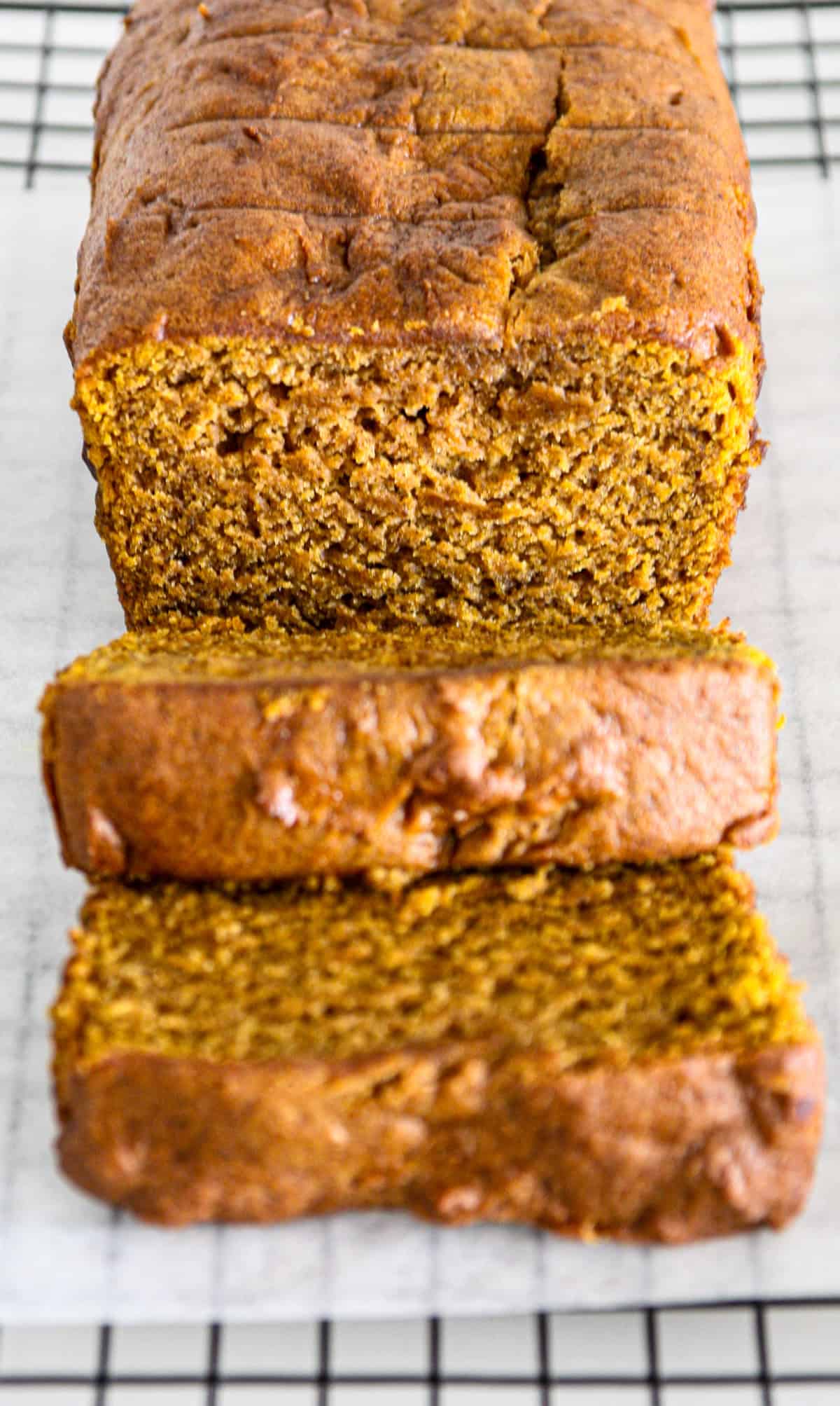 A gluten free pumpkin loaf with two slices cut from it.