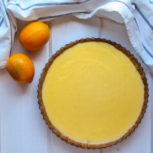 Top down photo of a Meyer lemon curd tart and two lemons.