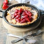 Top shot of strawberry Dutch baby gluten free in cast iron skillet.