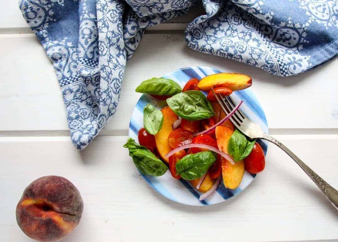 A plate of food on a table, with Peach basil and Tomato