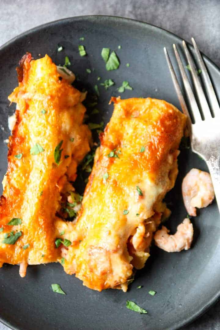 A plate of enchiladas with a fork