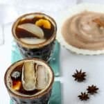 2 ginger snap cocktails with ginger slices for garnish on blue cocktail napkins