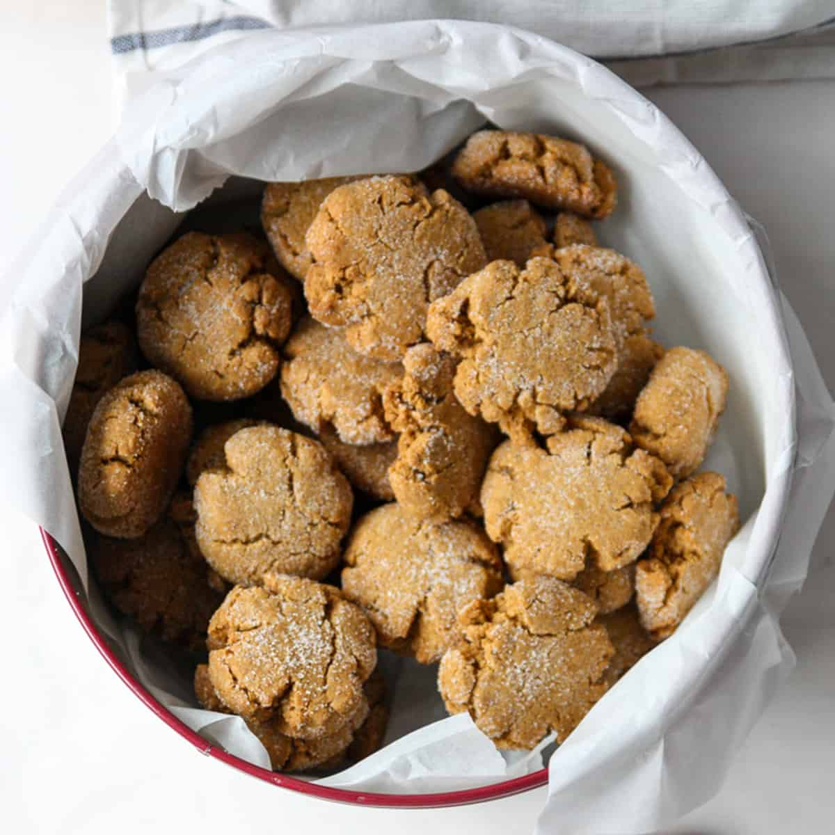 A cookie tin filled with molasses crinkle cookies.