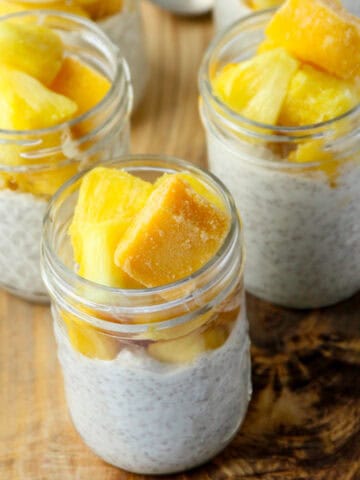 Three jars of chia pudding topped with mango.