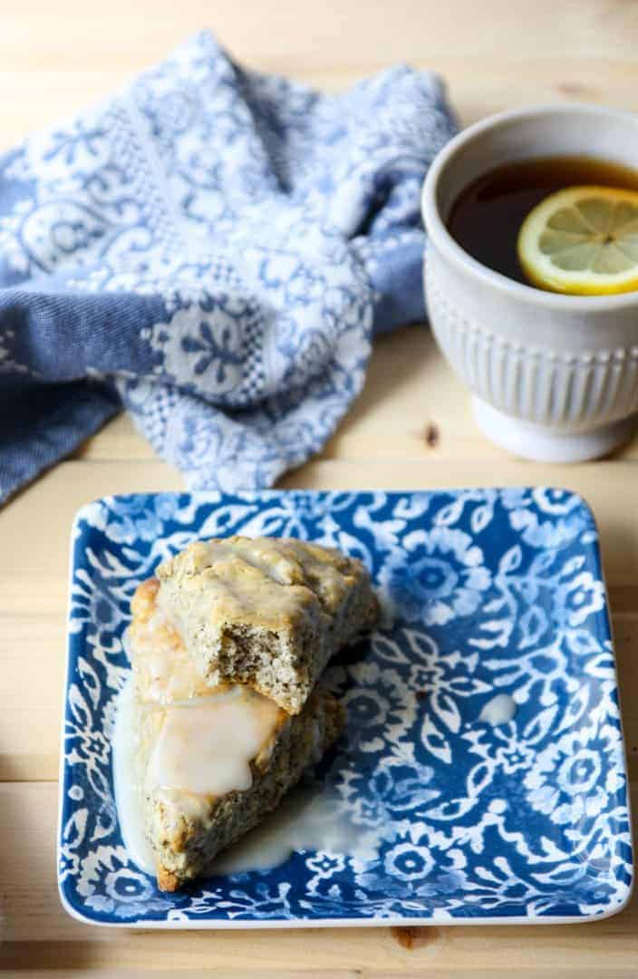 A scone on a plate next to a cup of tea