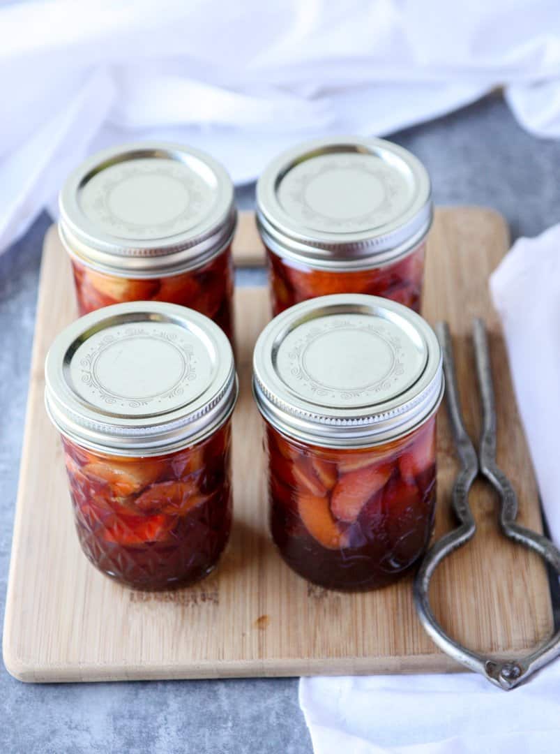 Four jars of pickles on a table