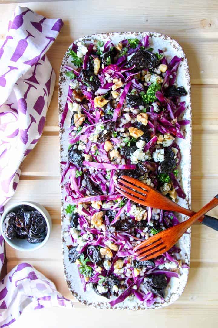 Prune Salad with buckwheat & red cabbage on a white platter