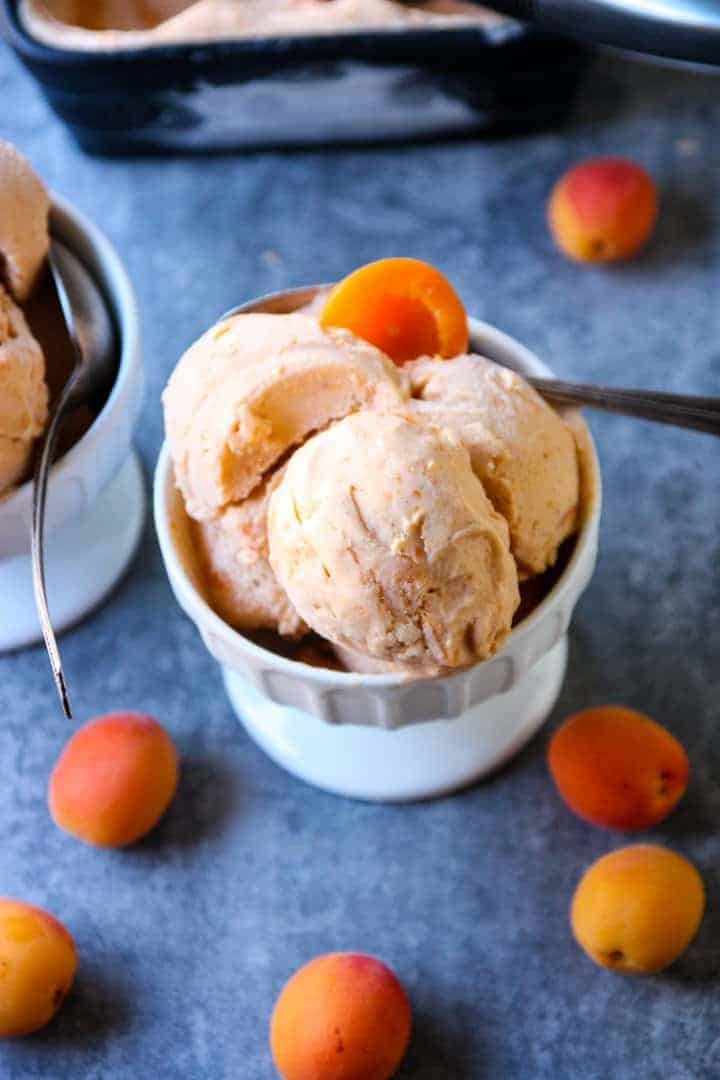 Three scoops of apricot mascarpone ice cream in a white dish