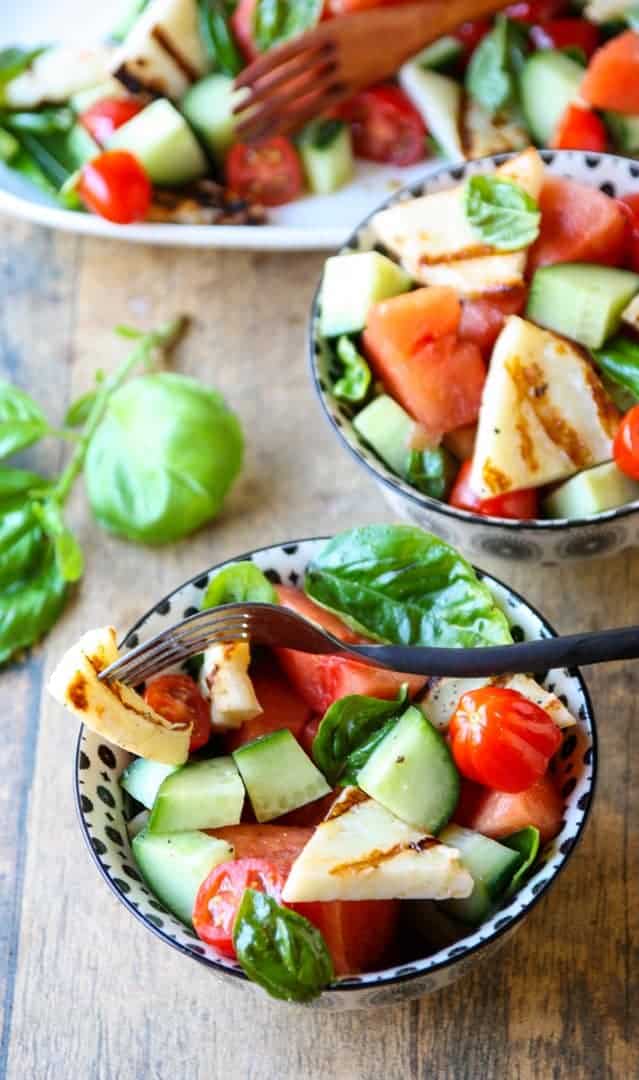 A bowl of fruit and vegetable salad, with Halloumi and Cucumber
