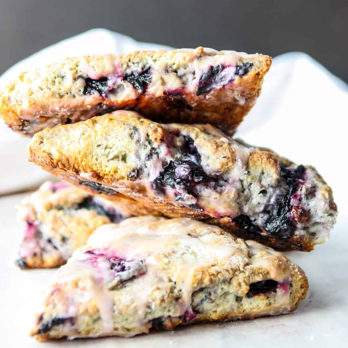 A stack of gluten-free blueberry scones on a white table.