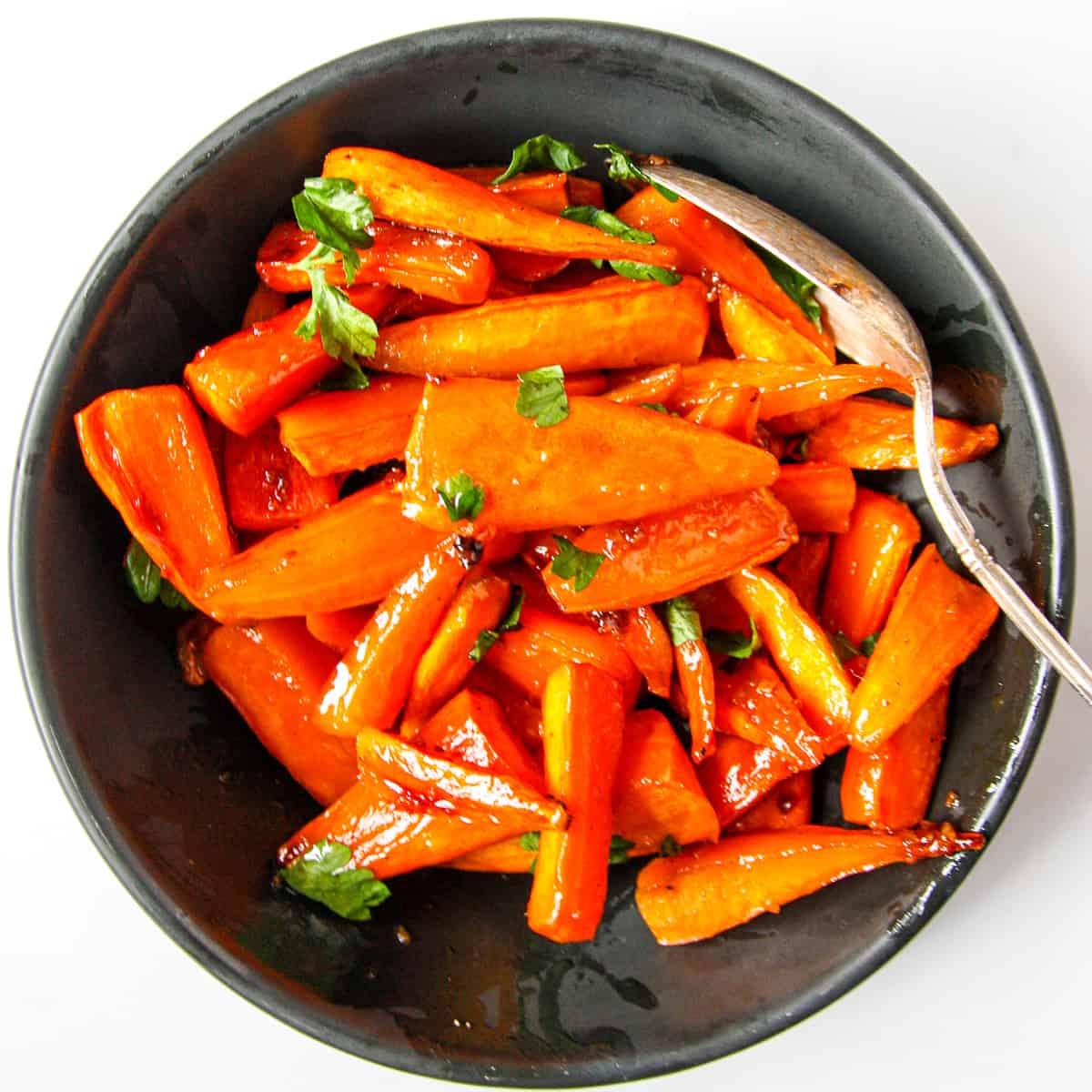 Brown sugar roasted carrots in a black dish.