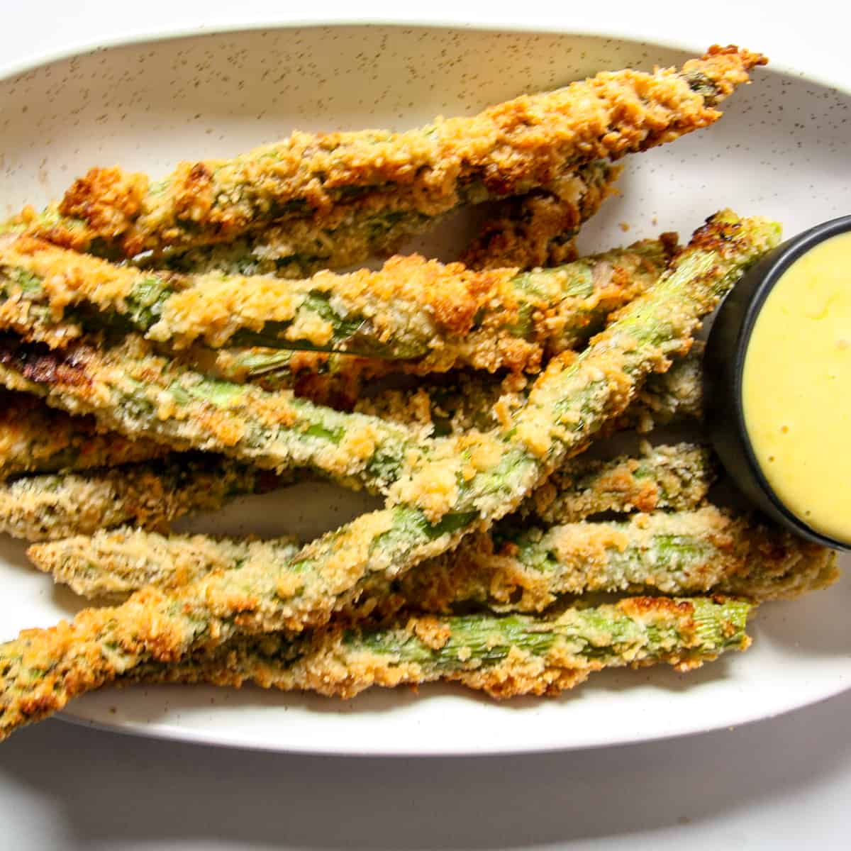 Crispy fried asparagus spears on a plate.