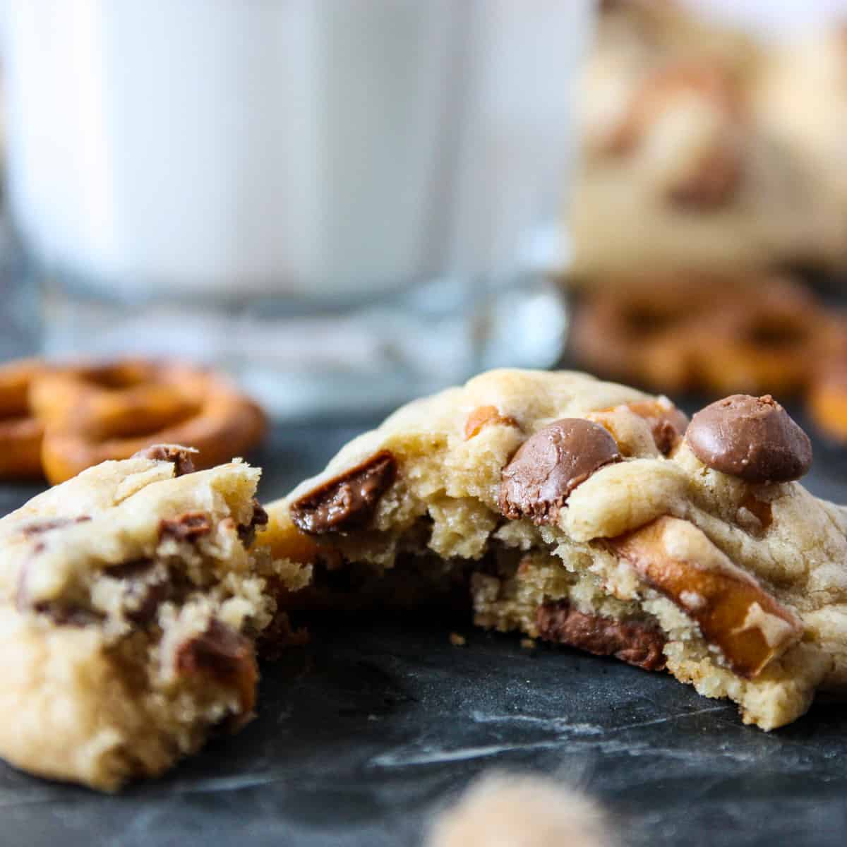 A close up of a freshly baked pretzel chocolate chip cookie broken in half.