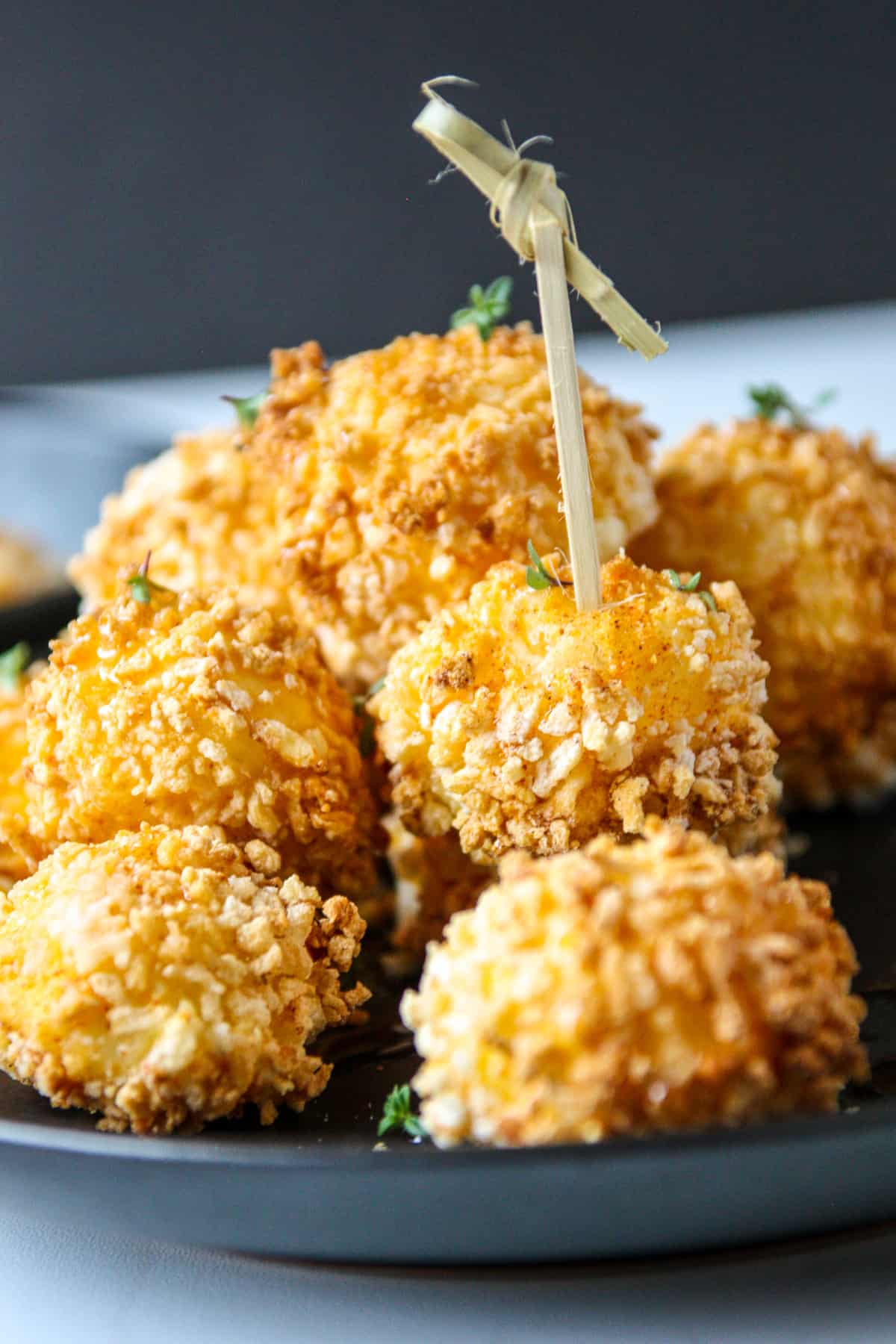 A pile of air fryer goat cheese balls on a plate ready to eat.