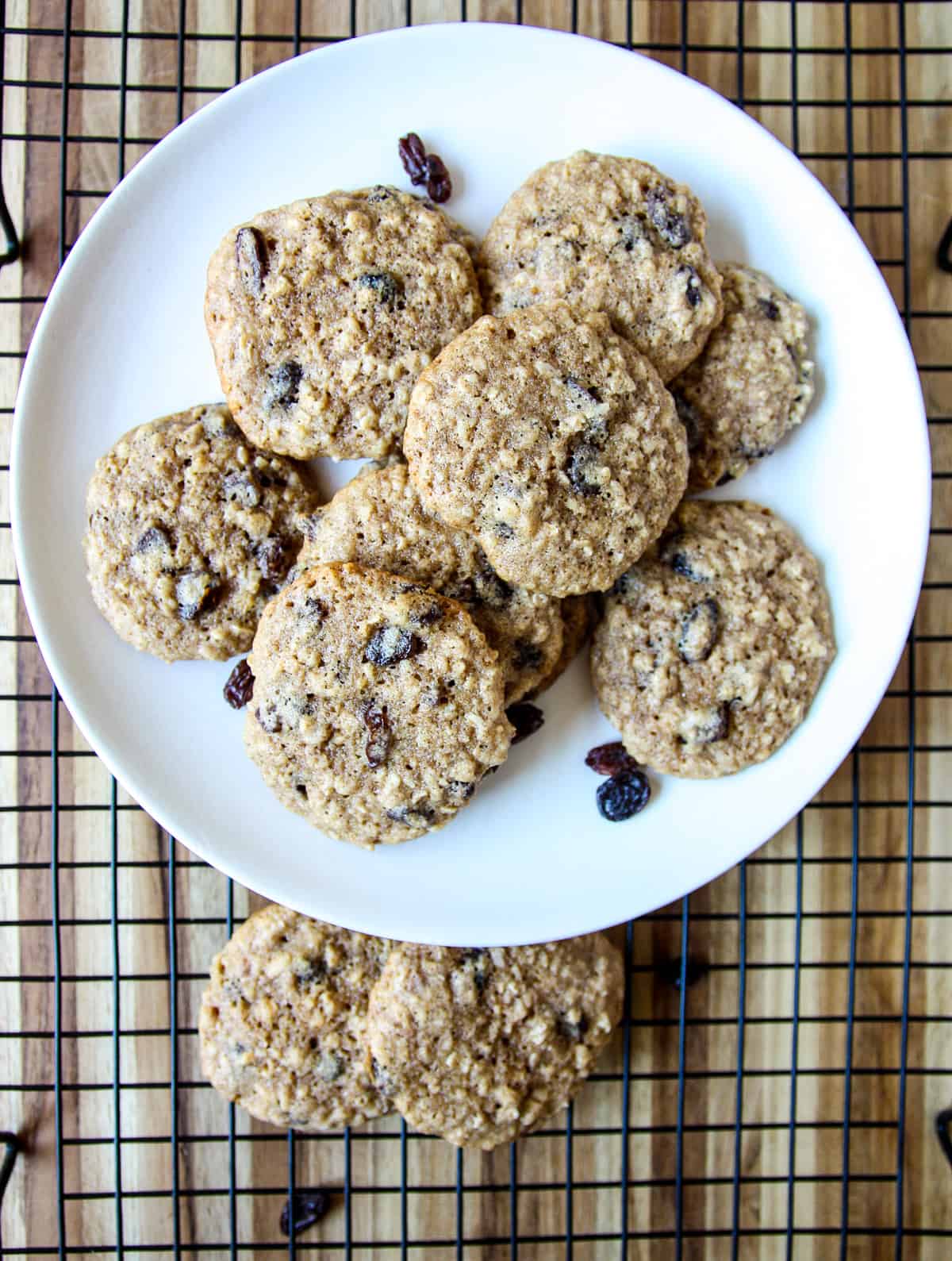 A white plate full of oatmeal raisin cookies.