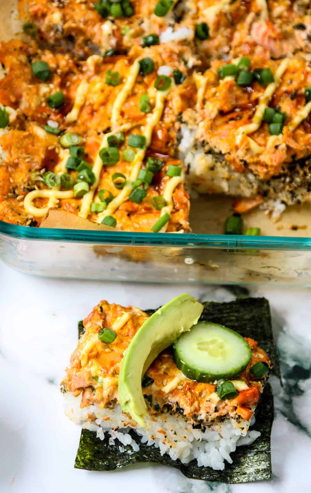 A slice of baked sushi on a square of toasted seaweed.