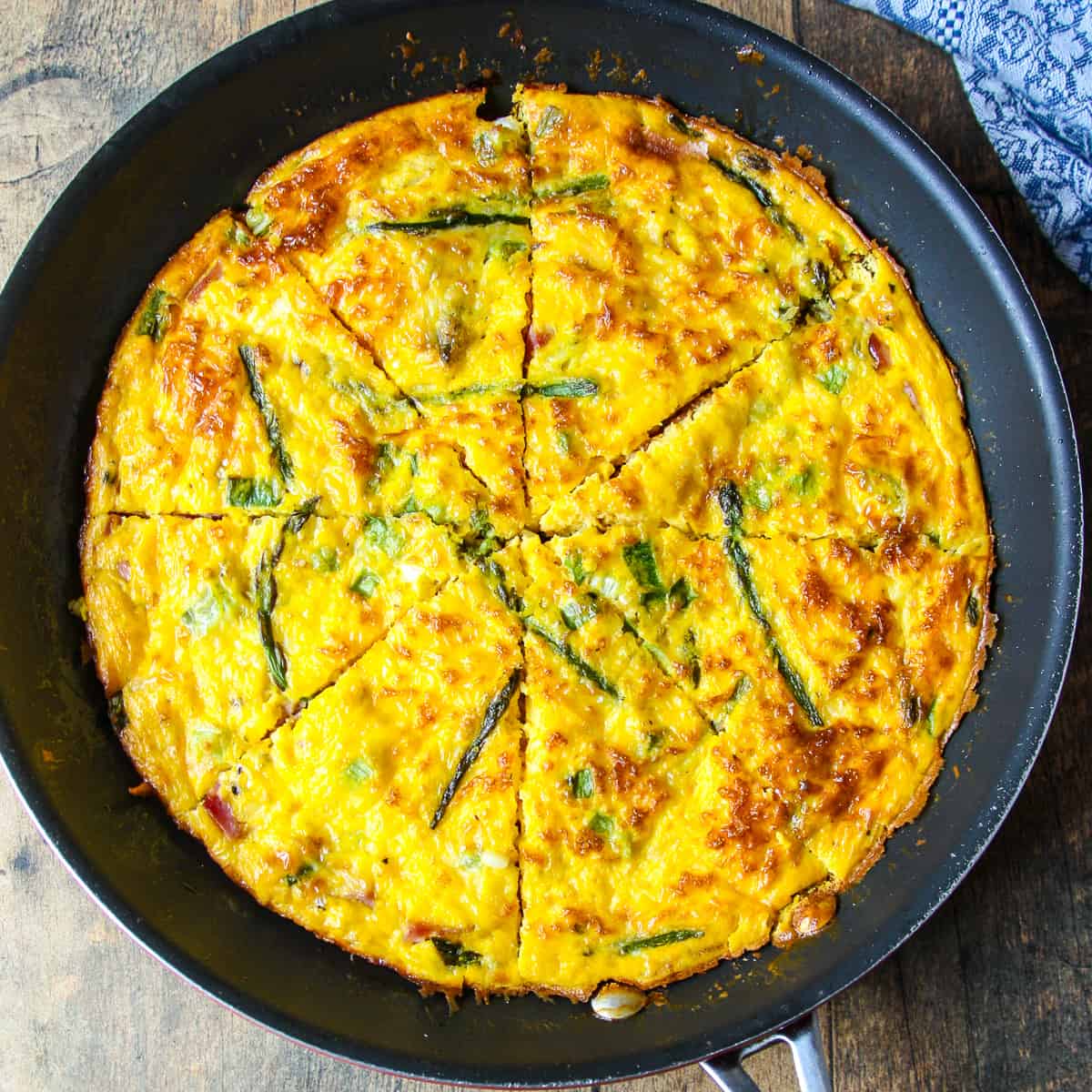 Baked ham and cheese frittata in a skillet.