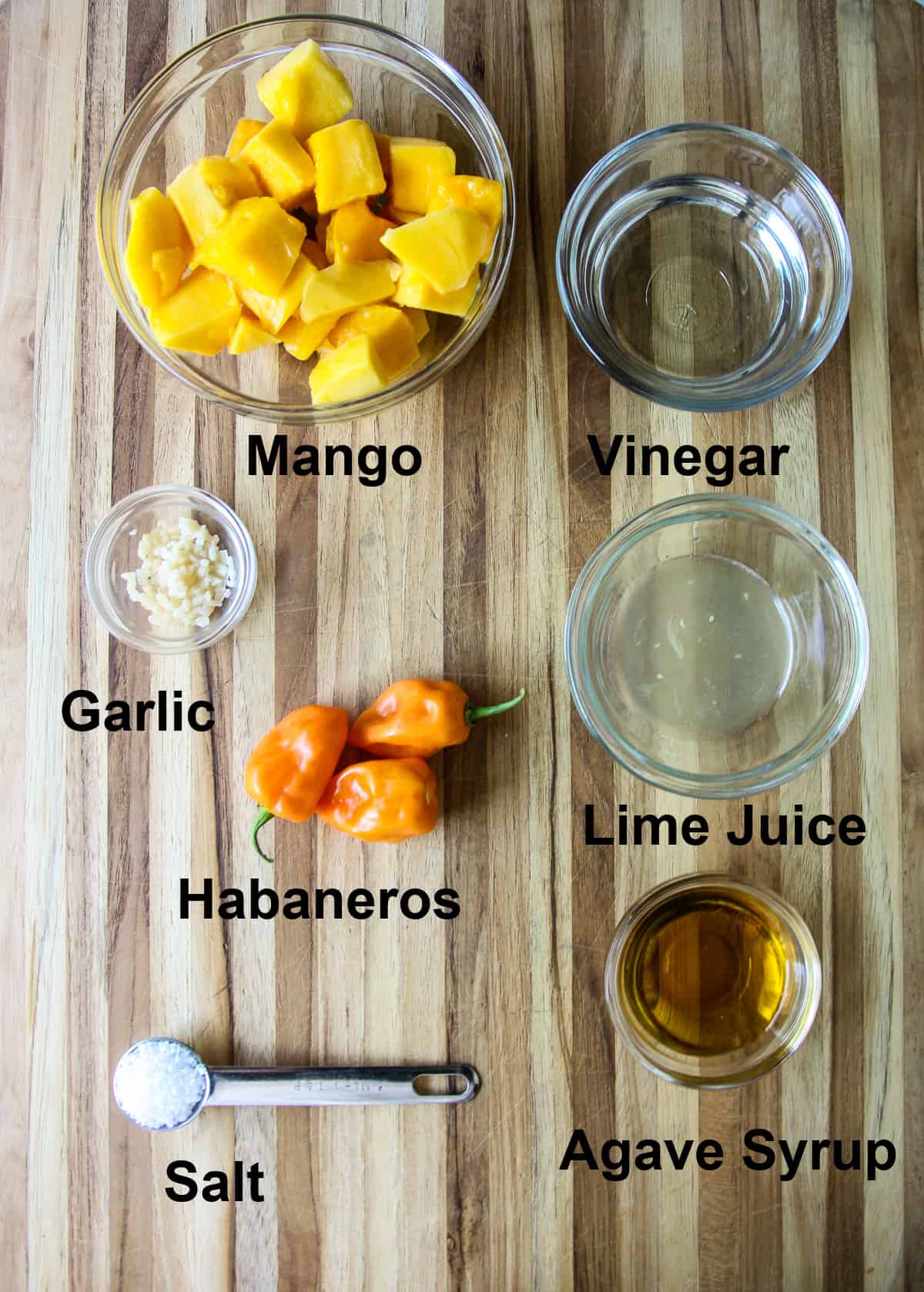 All of the ingredients to make this recipe in glass dishes on a wooden board.