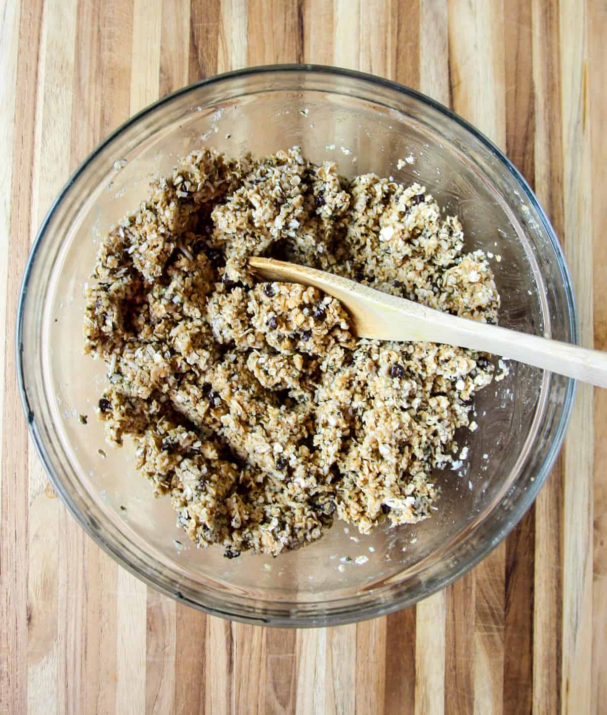 The ingredients being stirred together with a wooden spoon in a large bowl.