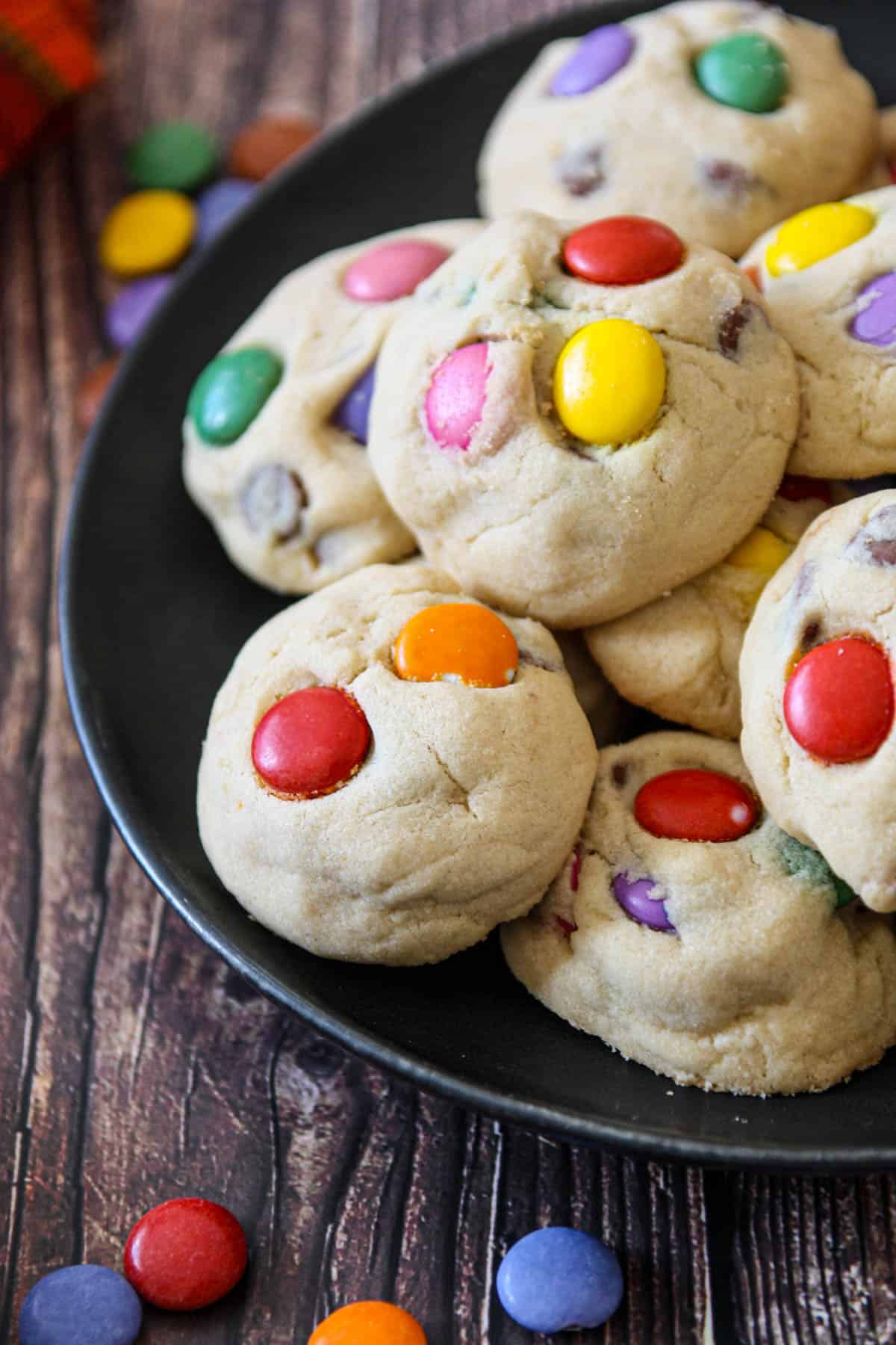 A plate full of smarties cookies studded with colorful candies.